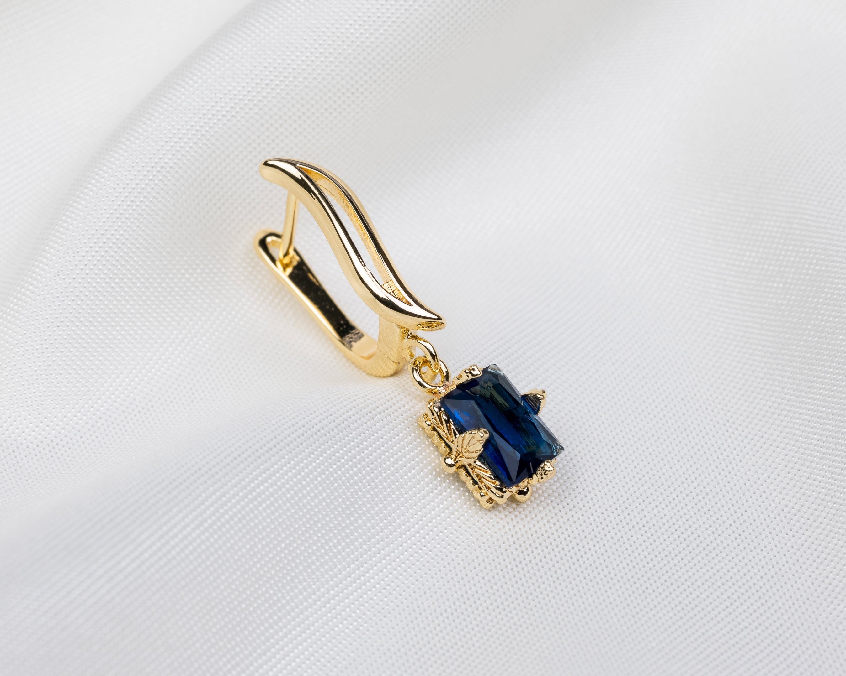 Handgemaakte 14k gold plated gebogen oorbel met een blauwe zirkonia hanger