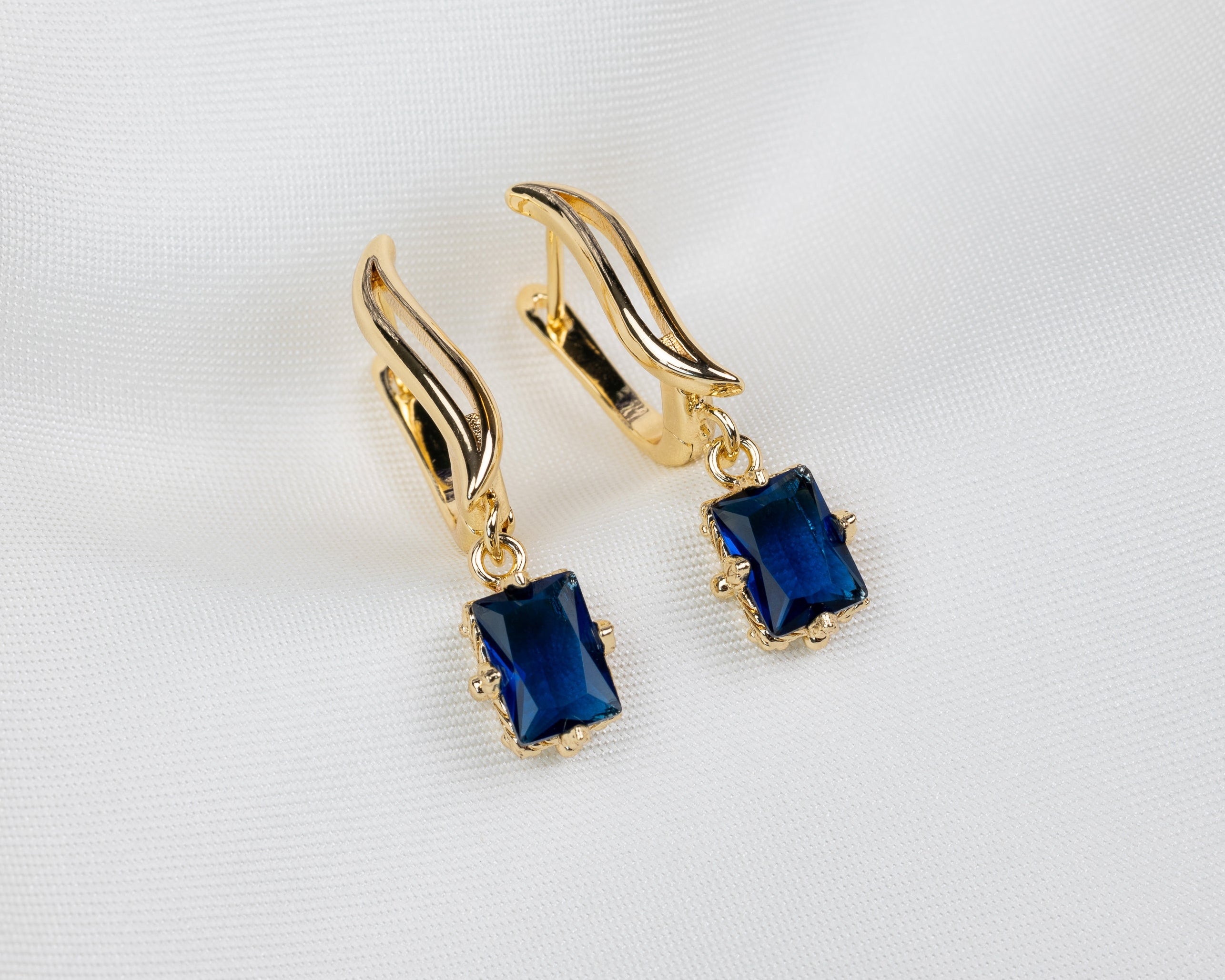 Handgemaakte 14k gold plated gebogen oorbellen met een blauwe zirkonia hanger