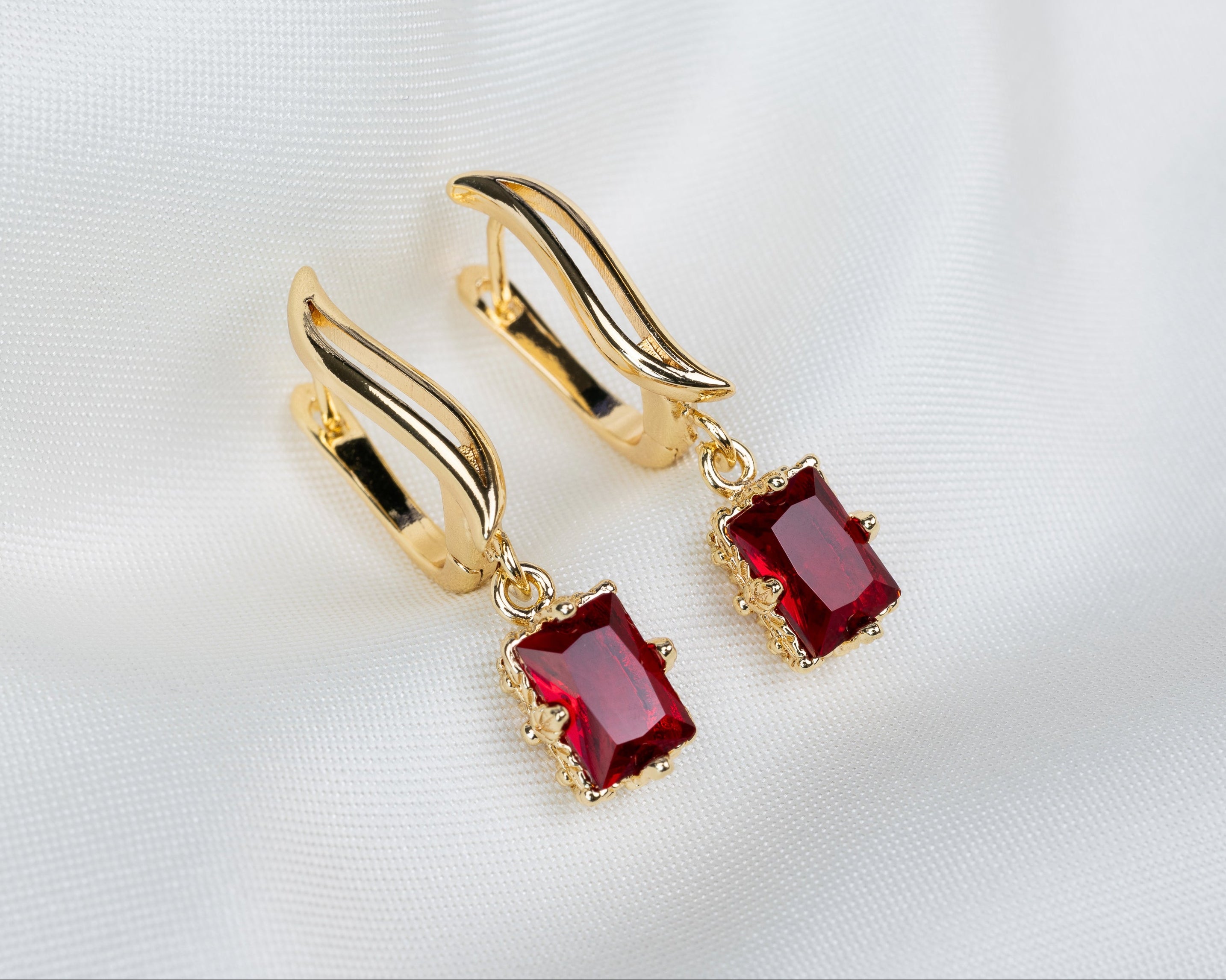 Handgemaakte 14k gold plated gebogen oorbellen met een rode zirkonia hanger