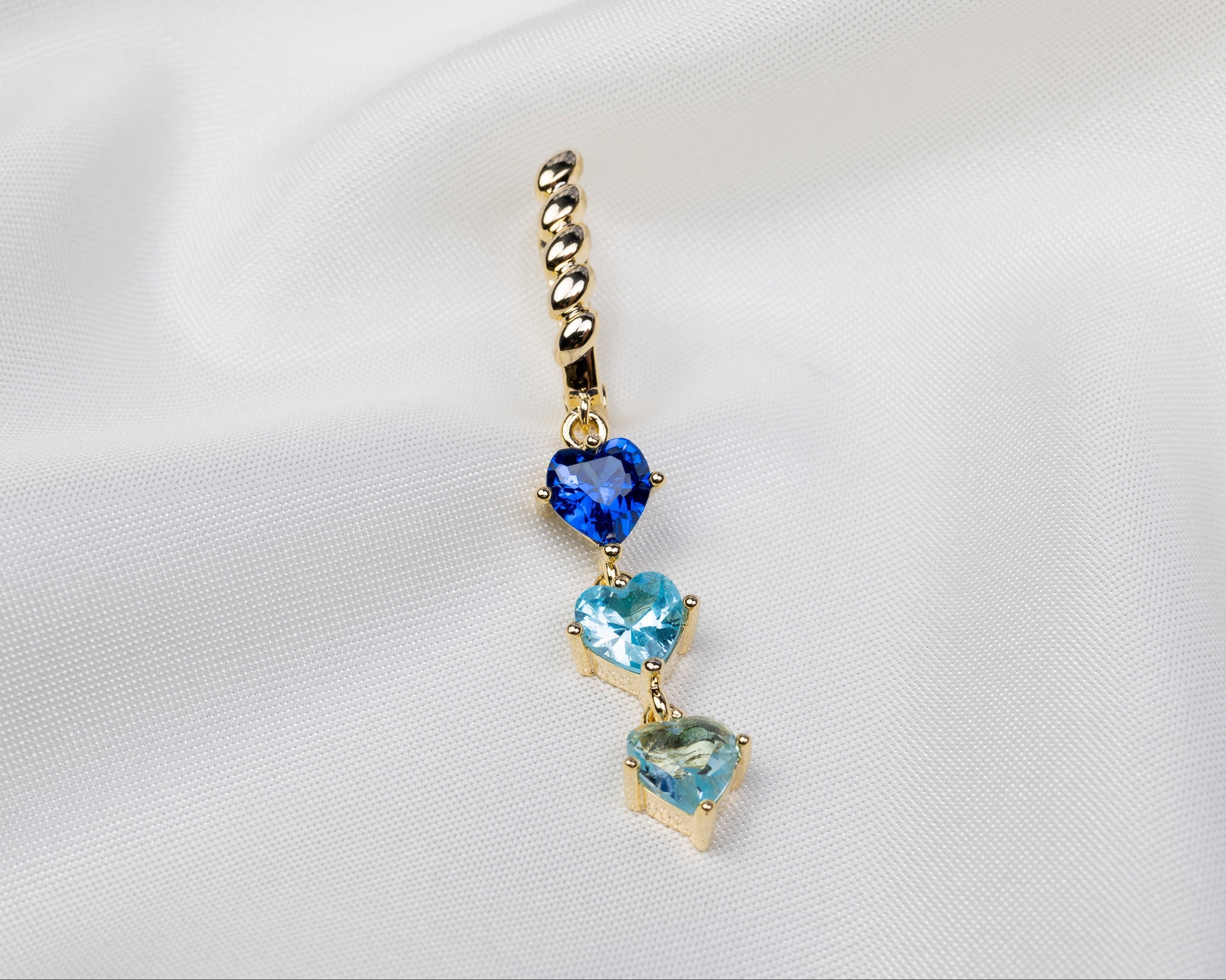 Handgemaakte 14k gold plated gedraaide oorbel met een hanger van drie blauwe zirkonia harten 