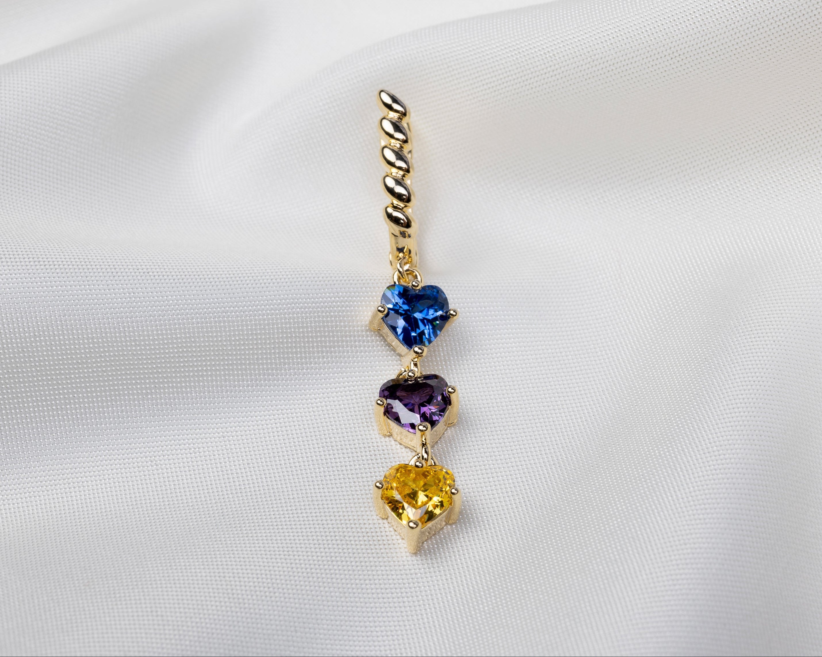 Handgemaakte 14k gold plated gedraaide oorbel met een hanger van drie gekleurde zirkonia harten 