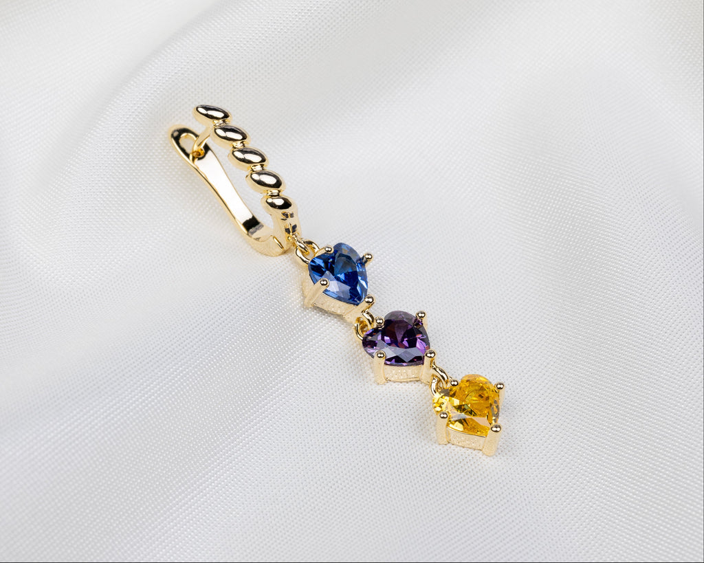 Handgemaakte 14k gold plated gedraaide oorbel met een hanger van drie gekleurde zirkonia harten 