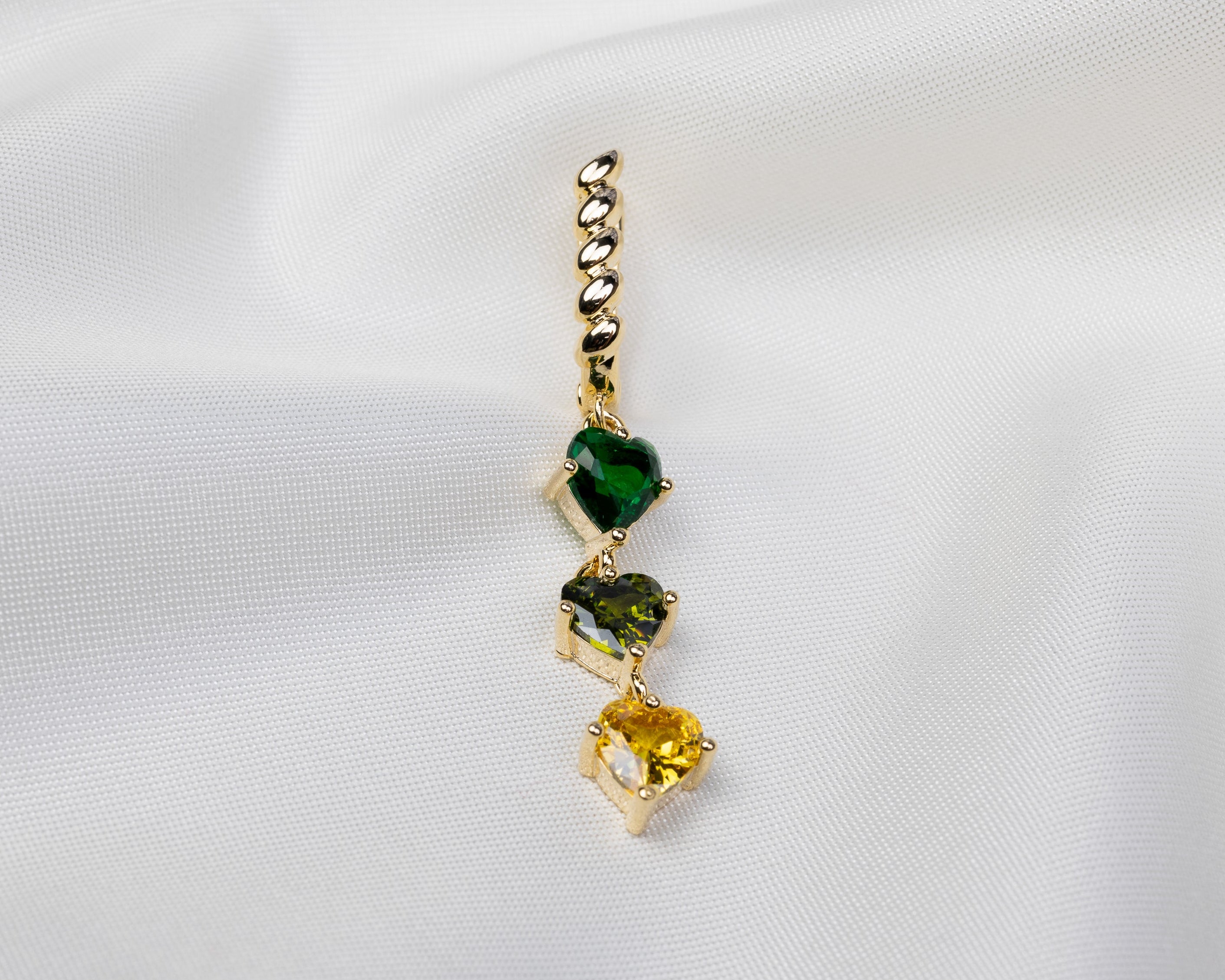 Handgemaakte 14k gold plated gedraaide oorbel met een hanger van drie groene zirkonia harten 