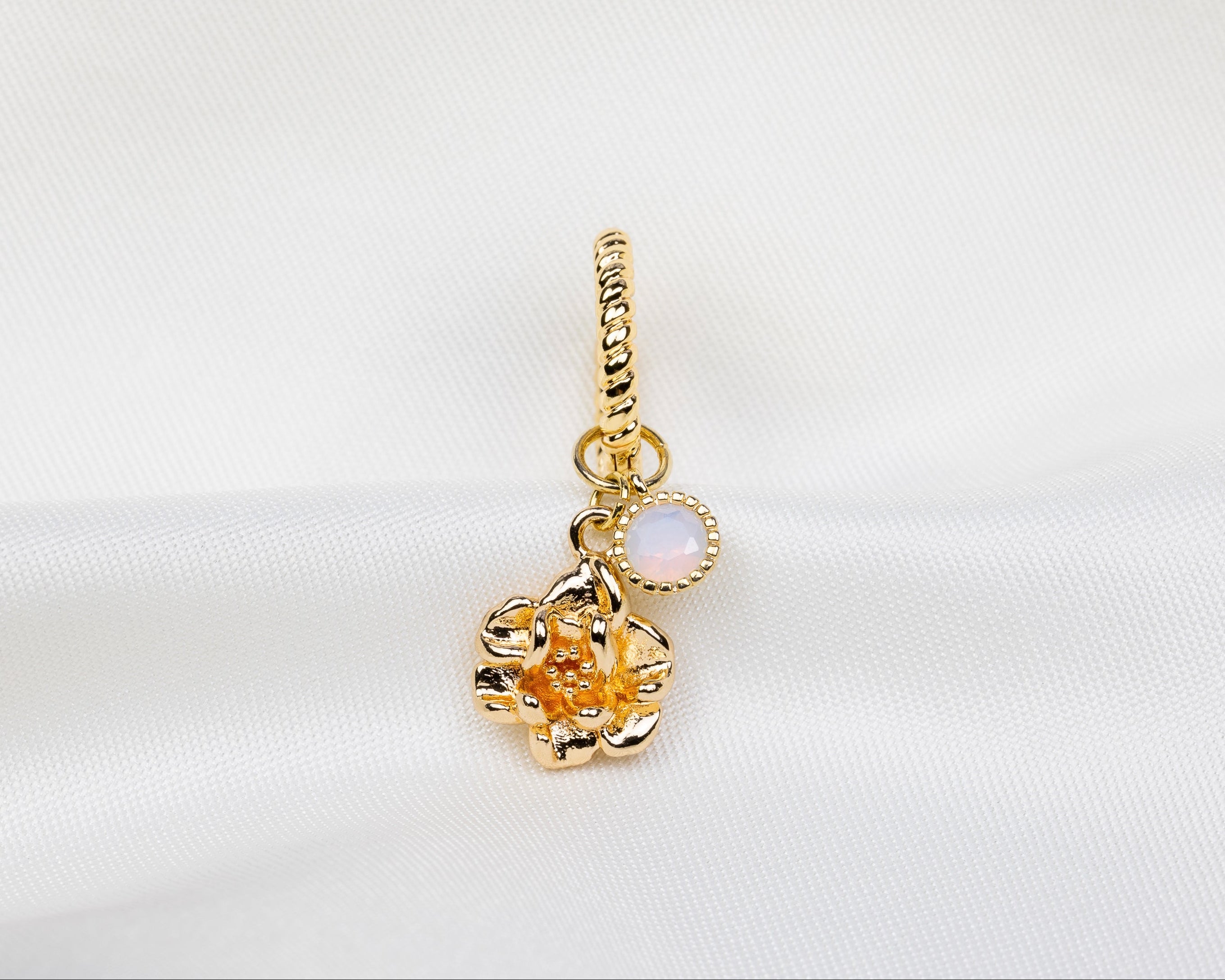 Handgemaakte 14k gold plated gedraaide oorbel met hanger in de vorm van een narcis bloem en opaal roze zirkonia steen