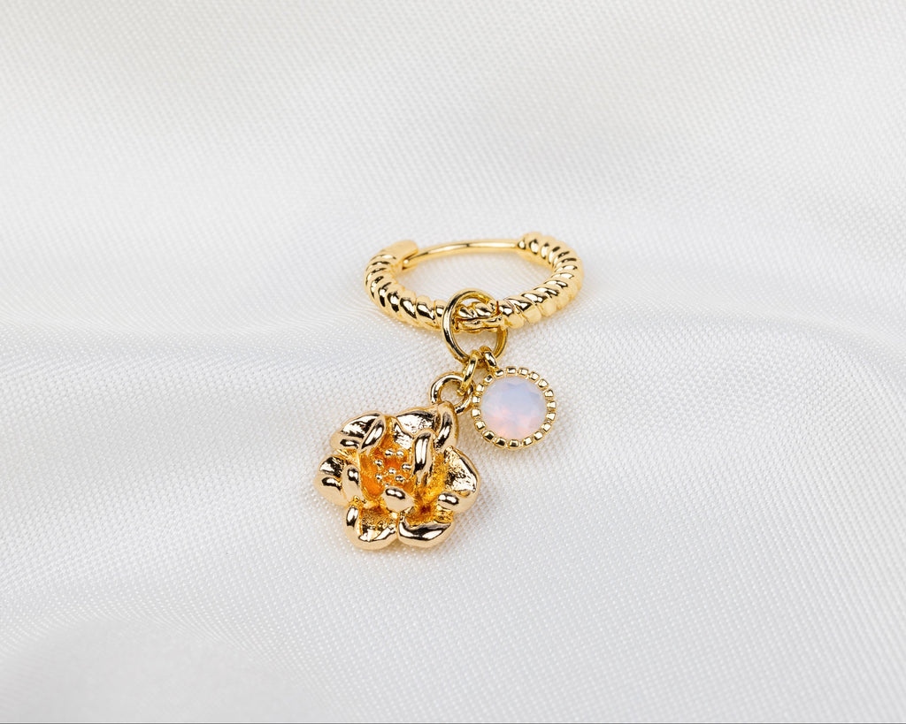 Handgemaakte 14k gold plated gedraaide oorbel met hanger in de vorm van een narcis bloem en opaal roze zirkonia steen