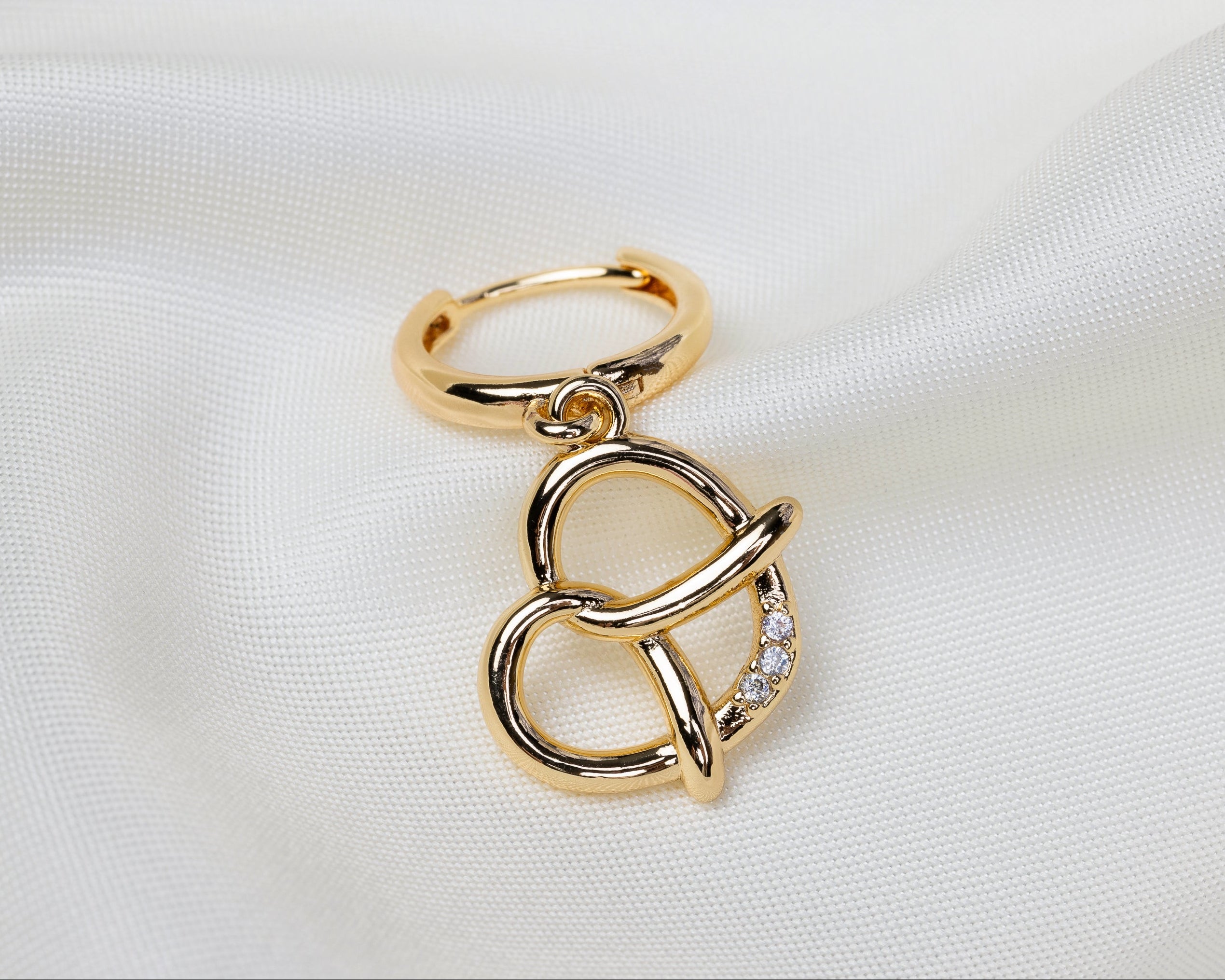 Handgemaakte 14k gold plated oorbel met een hanger in de vorm van een pretzel met witte zirkonia