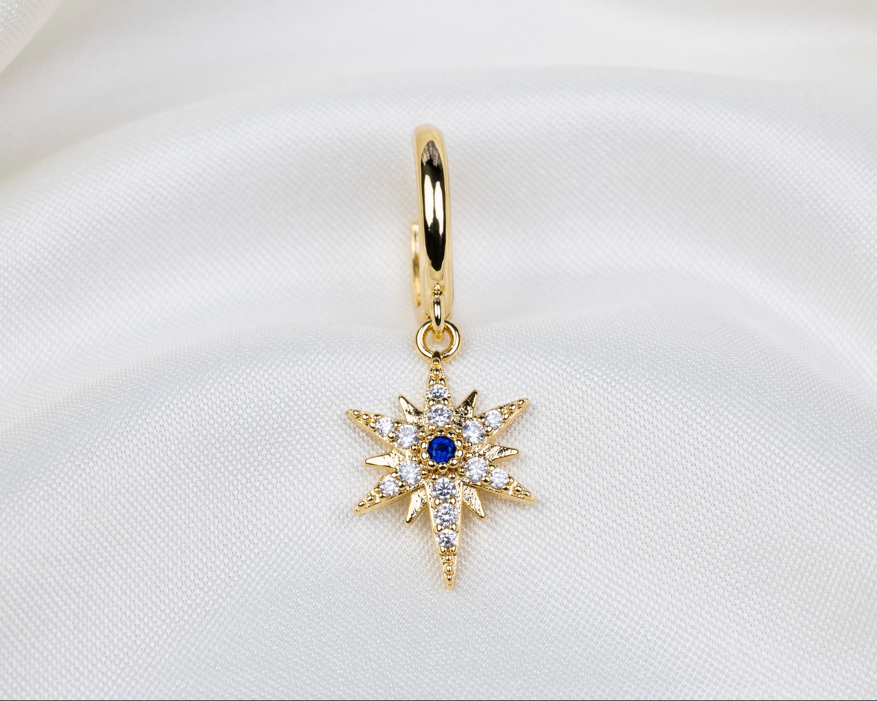 Handgemaakte 14k gold plated oorbel met een stervormige hanger van witte en blauwe zirkonia
