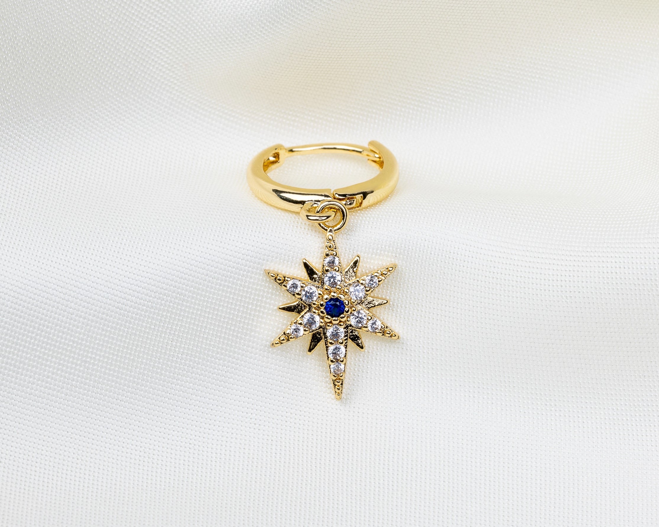 Handgemaakte 14k gold plated oorbel met een stervormige hanger van witte en blauwe zirkonia