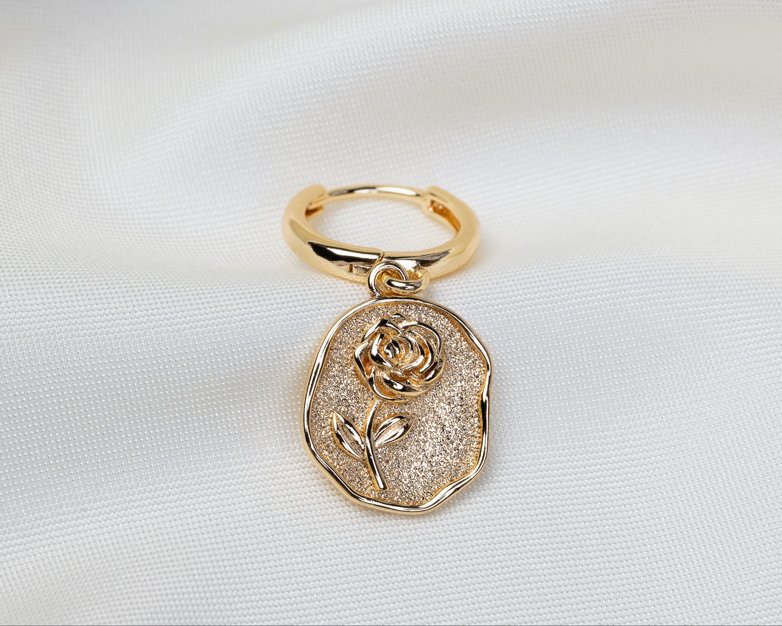 Handgemaakte 14k gold plated oorbel met een tablet-vormige hanger voorzien van een reliëf van een roos