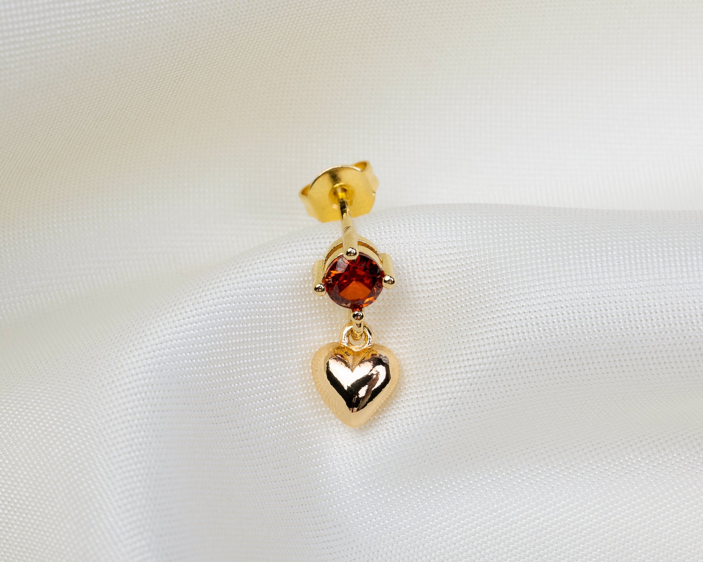 Handgemaakt 14k gold plated oorknopje met een rode zirkonia en hartvormige hanger