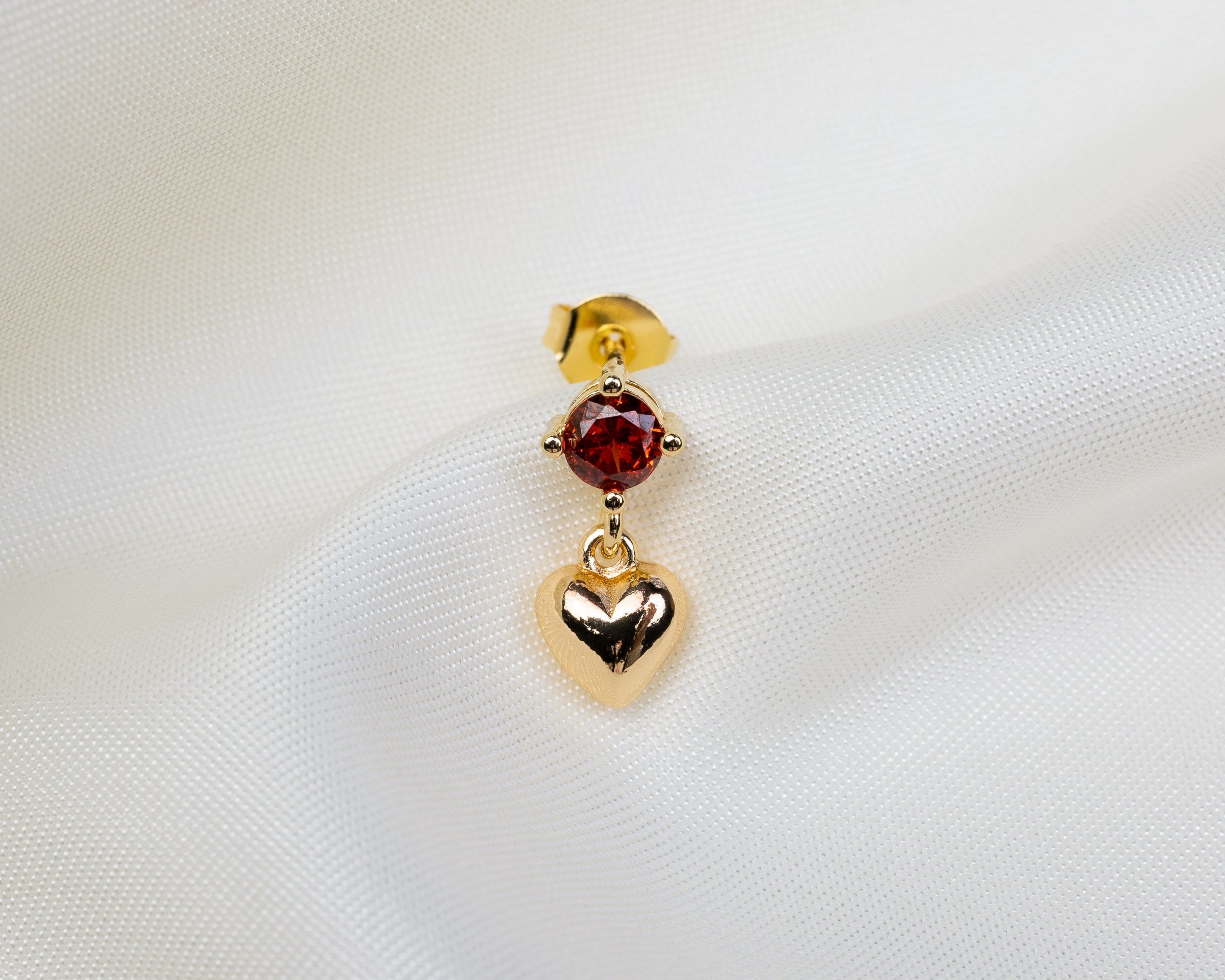 Handgemaakt 14k gold plated oorknopje met een rode zirkonia en hartvormige hanger