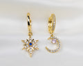 Set van twee handgemaakte 14k gold plated oorbellen met een maan en ster hanger van witte, roze en blauwe zirkonia
